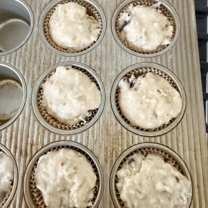 Muffin batter added to lined muffin cups before baking.