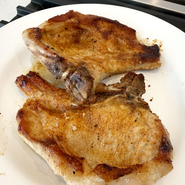 Pork chops on a plate after cooking.