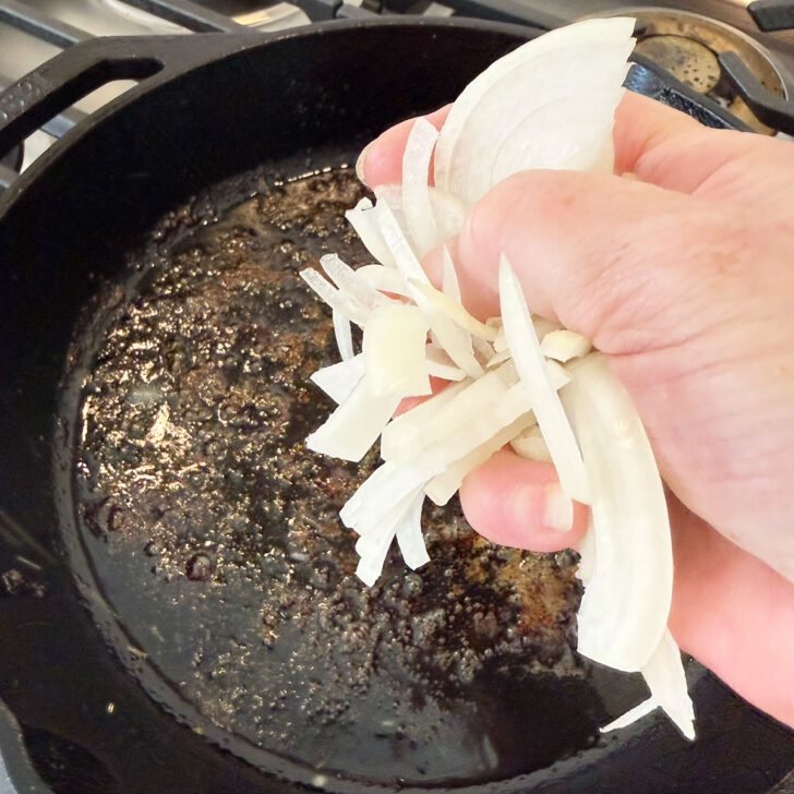 Adding onion to the skillet for the sauce.